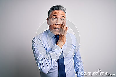 Middle age handsome grey-haired business man wearing elegant shirt and tie hand on mouth telling secret rumor, whispering Stock Photo