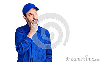 Middle age handsome man wearing mechanic uniform with hand on chin thinking about question, pensive expression Stock Photo