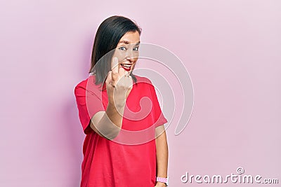 Middle age hispanic woman wearing casual clothes beckoning come here gesture with hand inviting welcoming happy and smiling Stock Photo