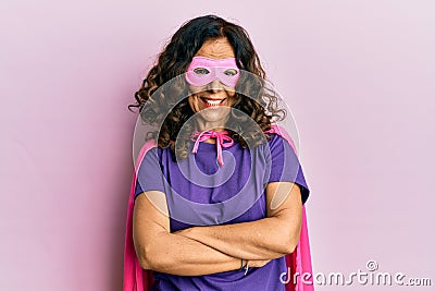 Middle age hispanic woman wearing super hero costume happy face smiling with crossed arms looking at the camera Stock Photo