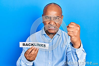 Middle age latin man holding paper with backlinks message annoyed and frustrated shouting with anger, yelling crazy with anger and Stock Photo