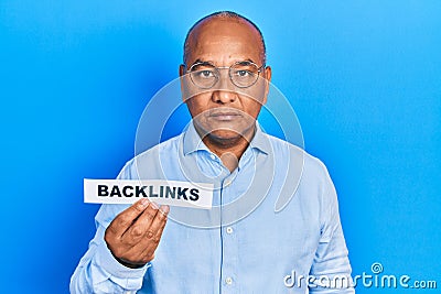 Middle age latin man holding paper with backlinks message thinking attitude and sober expression looking self confident Stock Photo