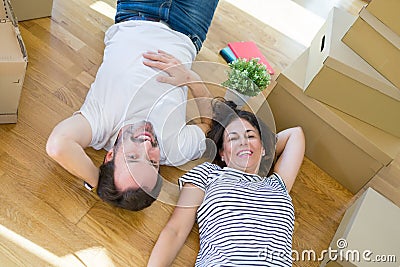 Middle age senior romantic couple lying on the floor, smiling happy for moving to a new house, relaxing and taking a break of Stock Photo