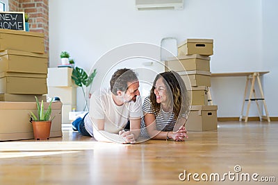 Middle age senior romantic couple lying on the floor, smiling happy for moving to a new house, relaxing and taking a break of Stock Photo