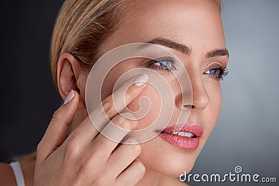 Middle age woman checking her face Stock Photo