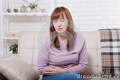 Middle age Woman with menstruation periods stomach pain at home background. Copy space and mock up. Menopause concept Stock Photo