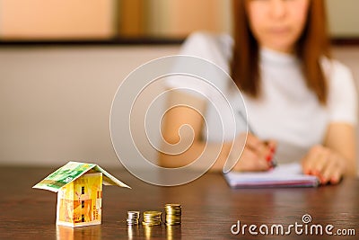 Middle age Woman With Model House from Israel Currencies New Israeli Shekel. Stock Photo