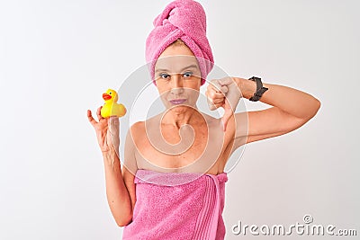 Middle age woman wearing shower towel holding duck toy over white background with angry face, negative sign showing Stock Photo