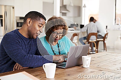 Middle aged African American man helping his mother use a laptop computer at home, close up Stock Photo