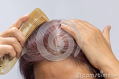 Middle aged asian woman concern about gray hair in menopause Stock Photo