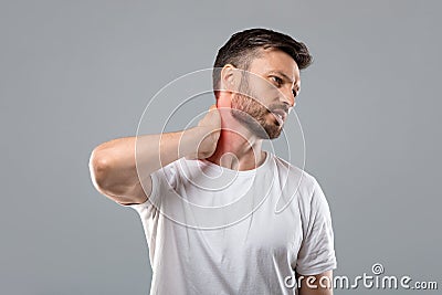 Middle aged bearded man touching his inflammated neck Stock Photo