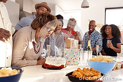 Middle aged African American woman cutting cake during a three generation family birthday celebration,close up Stock Photo