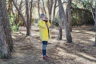 Woman makes photos with analog reflex camera in the forest Stock Photo