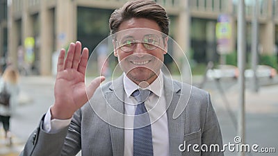 Middle Aged Businessman Waving Handfor Hello outdoor Stock Photo