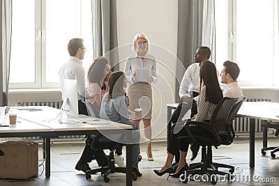 Middle aged businesswoman boss mentor training interns employees in office Stock Photo