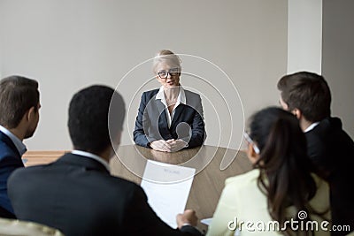 Middle-aged confident applicant talking to hr managers during job interview Stock Photo