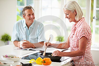 Middle Aged Couple Cooking Meal In Kitchen Together Stock Photo