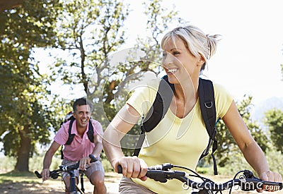 Middle Aged Couple Cycling Through Countryside Stock Photo