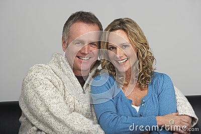 Middle Aged Couple Sitting On Sofa Stock Photo