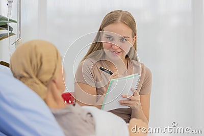 A middle-aged end-state breast cancer patient lay on the bed and tells her life`s story for a ghostwriter to write her biography Stock Photo