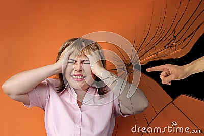 Middle-aged European woman stands protestingly extending both hands, cracks, male hand shows an accusatory finger, orange Stock Photo