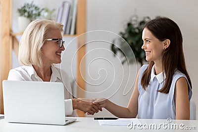 Aged employer congratulates young woman with job interview successful accomplishment Stock Photo