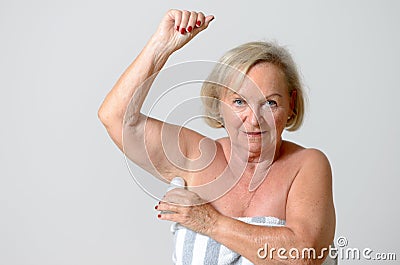 Middle Aged Lady Applying Deodorant on Armpit Stock Photo