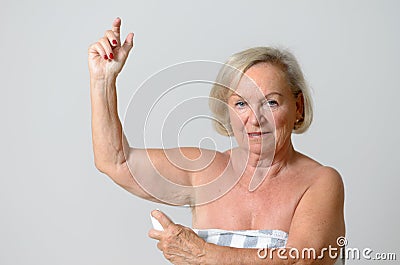 Middle Aged Lady Applying Deodorant on Armpit Stock Photo