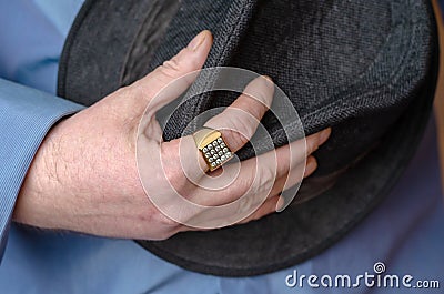 A middle-aged man in a blue shirt clutches his hat. Stock Photo