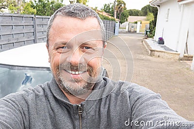 Middle aged man handsome make selfie in home alley garden guy happy with smartphone Stock Photo