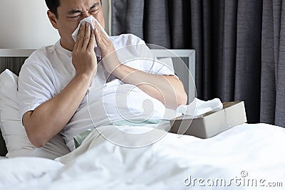 Middle aged man having allergies,hay fever,runny nose and sneeze,nasal congestion,sinusitis,blow the nose with tissue paper, Stock Photo