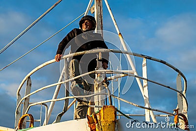 Middle-aged man playing captain on a boat stranded on an Icelandic beach Stock Photo