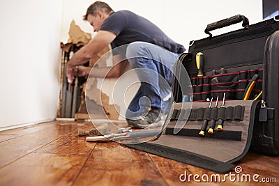 Middle aged man repairing burst pipe,plumbing, focus on foreground Stock Photo