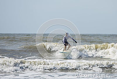 Middle aged man surfs on a longboard in the Atlantic Stock Photo