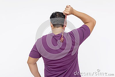 A middle aged man using a backscratcher to scracth and relieve an itch on his upper back. Rear view, isolated on a white Stock Photo