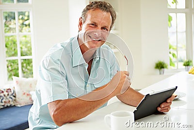 Middle Aged Man Using Digital Tablet Over Breakfast Stock Photo