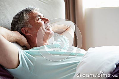 Middle Aged Man Waking Up In Bed Stock Photo