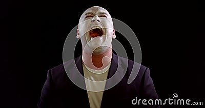 Middle aged man with white greasepaint on face is laughing and demonstrating angry, portrait Stock Photo