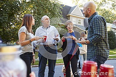 Middle aged and senior neighbours talking at a block party Stock Photo