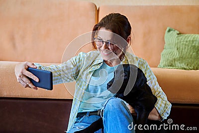 Happy female dog owner taking selfie photo on smartphone Stock Photo