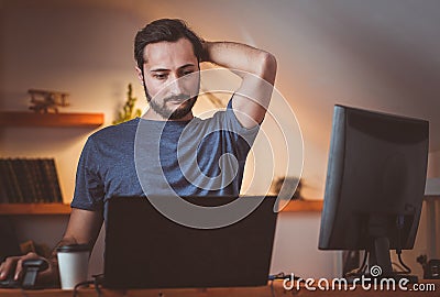 A middle-aged student pondered a problem during an evening class at home Stock Photo