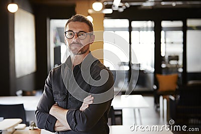 Middle aged white male creative wearing glasses standing in an office looking to camera, waist up Stock Photo