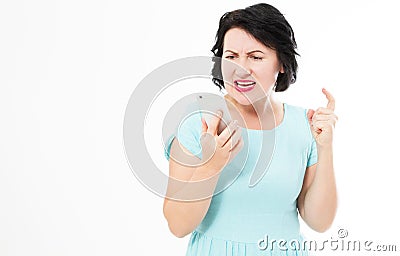 Middle aged woman in blue dress using smartphone stressed, shocked with shame and surprise face, angry and frustrated Stock Photo