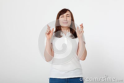 Middle aged woman crossing her fingers and wishing for good luck. Blank white t-shirt, mock up. Fashion outfit Mother day Stock Photo