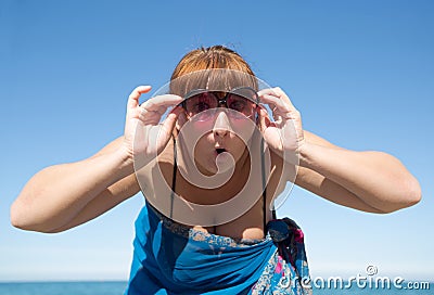 Middle-aged woman looks at camera through tinted sunglasses Stock Photo