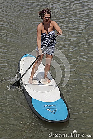 Middle aged woman on stand-up paddle board enjoying herself Editorial Stock Photo