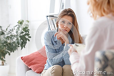 Female psychologyst therapy session with client indoors sitting girl looking at therapist Stock Photo