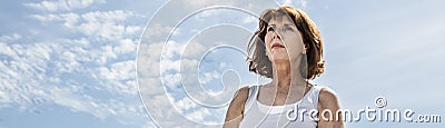 Middle aged yoga woman seeking for balance over summer sky Stock Photo