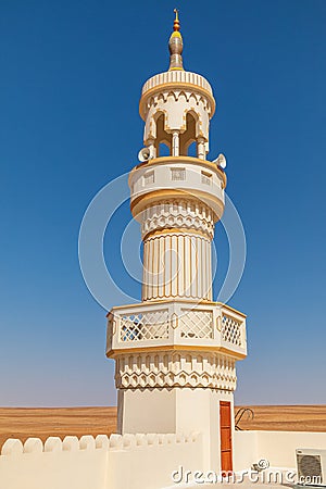 The minaret of a mosque in the desert of Oman Stock Photo