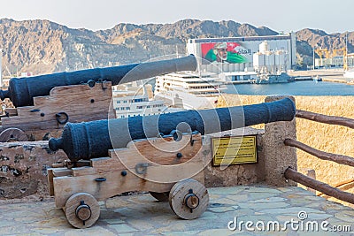 Ancient cannons overlooking the harbor at Muttrah Fort. Editorial Stock Photo